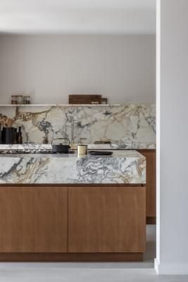 a kitchen with marble counter tops and wooden cabinets