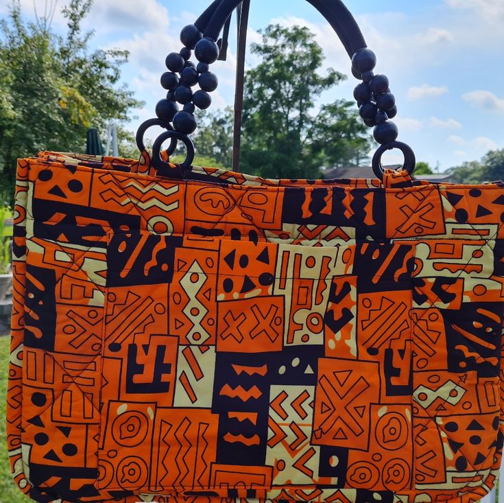 Adametu Collection Quilted Earth Toned Print Ankara Tote Bag . Cool For This Summer Vacation Or A Overnight Stay. Anything Goes ! Made With A Inside Pocket For Your Keys And Cell Phone. 100%Cotton Fabric Orange Square Shoulder Bag For Everyday Use, Casual Orange Bag With Handles, Orange Double Handle Shoulder Bag For Beach, Casual Orange Shoulder Bag With Handles, Casual Orange Satchel With Double Handle, Orange Rectangular Bag For Daily Use, Orange Square Bag For Daily Use, Orange Tote Bag For Daily Use, Orange Tote Shoulder Bag For Daily Use