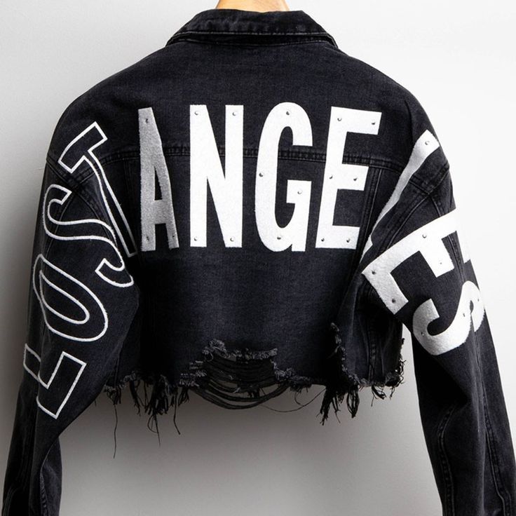 Cropped Distressed Denim Jacket Features Wide Back Patches With The Letters Wording "Lost Angeles" (Light Rhinestone On Letters) Distress Hemline, Long Sleeves, Collar, Front Button Down And Chest Pockets. (Please Note That All Of Our Products Are Hand Made And Include Hand Work So Depending On The Number Of Units Your Order Might Take 1-2 Days To Complete You Will Receive An Email Or Call For Completed Order) 78% Cotton 15% Rayon 7% Polyester Made In China Denim Jacket Personalized, Streetwear Fashion Women Winter, Denim Leather Jacket, Denim Jacket Black, Crop Denim Jacket, Crystal Makeup, Loft Ideas, Oversized Jean Jacket, Metallic Jeans