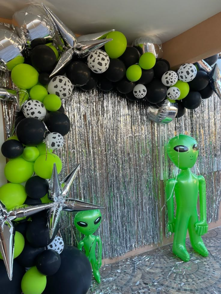 balloons and decorations are displayed in front of a balloon arch with stars, moon, and alien figures