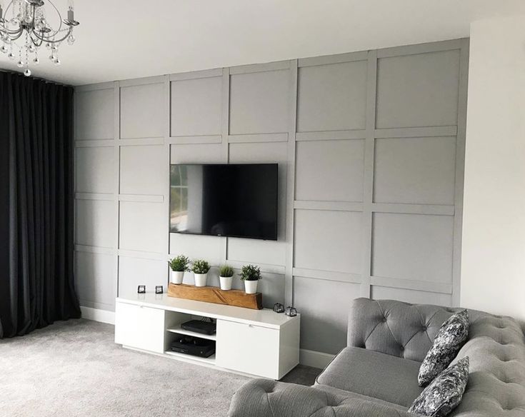 a living room filled with furniture and a flat screen tv mounted to the side of a wall