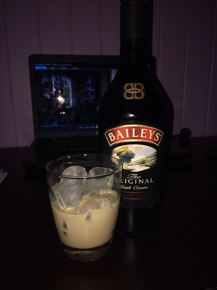 a bottle of bailey's irish cream next to a glass with ice