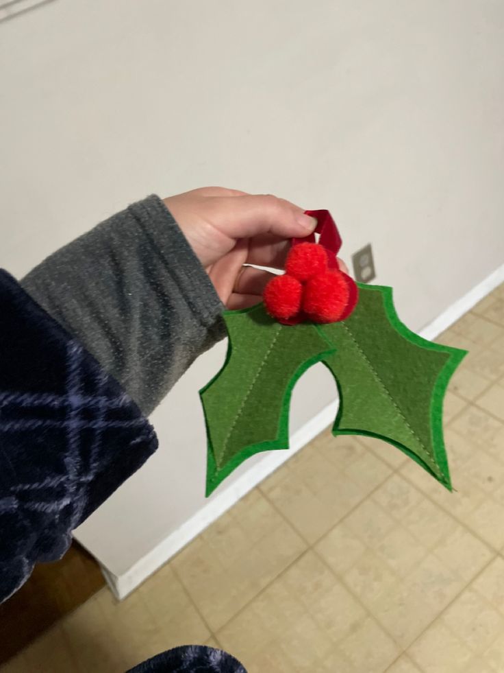 a person holding a piece of felt with two poinsettis on it