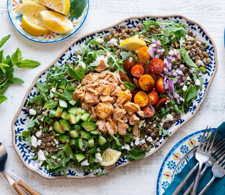 a salad with chicken, tomatoes, cucumbers and other vegetables