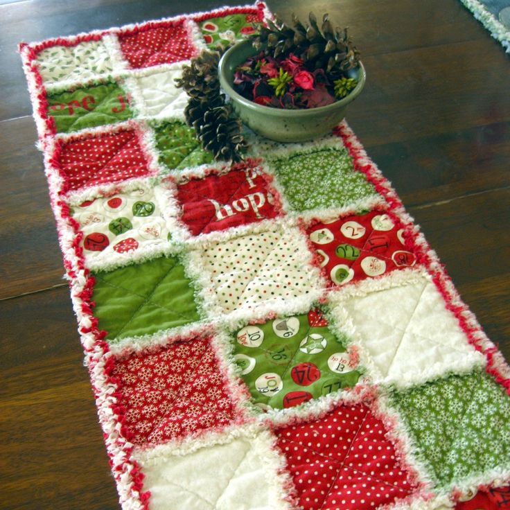 a potted plant sitting on top of a table next to a red and green quilt