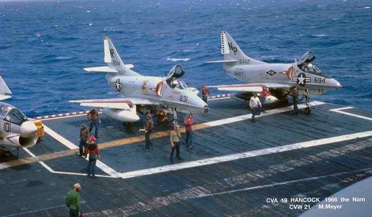 several fighter jets are parked on the deck of an aircraft carrier in the middle of the ocean