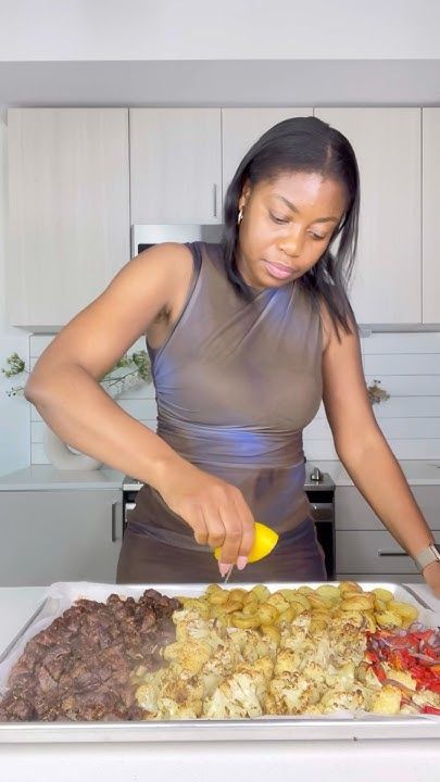 a woman is cutting up food on a tray in front of the stove top and counter