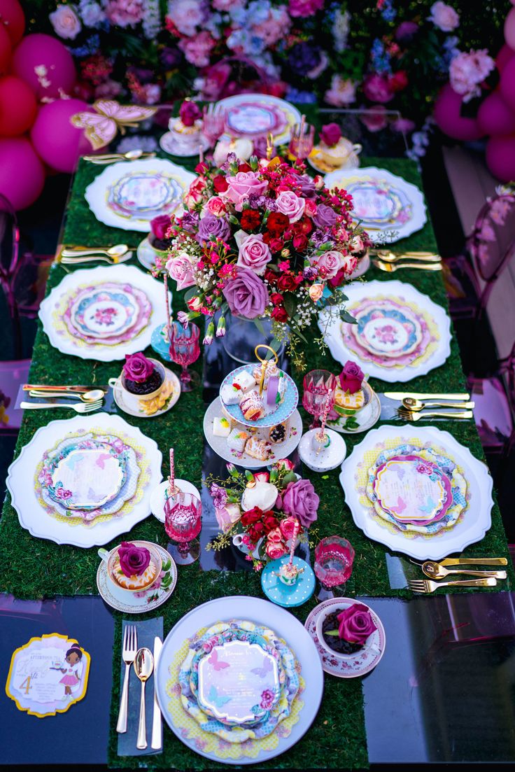 the table is set with plates and flowers