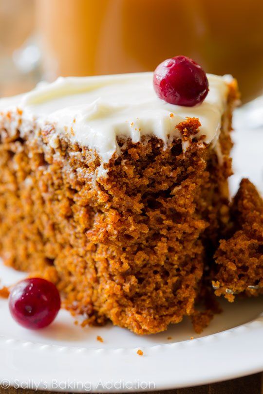 a piece of carrot cake with cream cheese frosting and cherries on the top