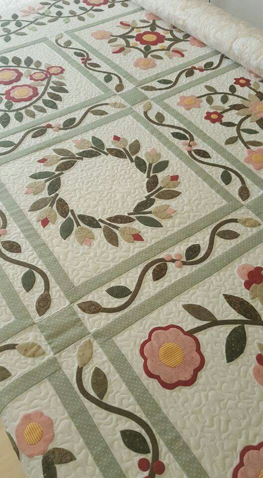 a bed with a floral quilt on top of it