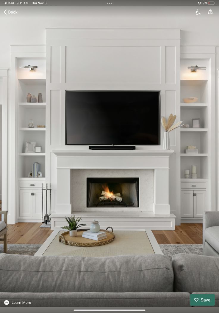 a living room filled with furniture and a flat screen tv mounted on the wall above a fire place