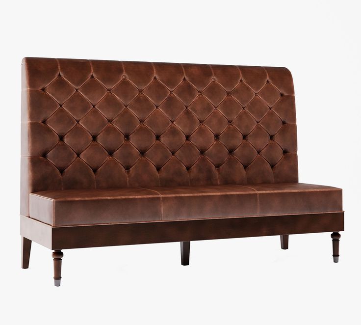 a brown leather couch with wooden legs and an upholstered headboard on the back