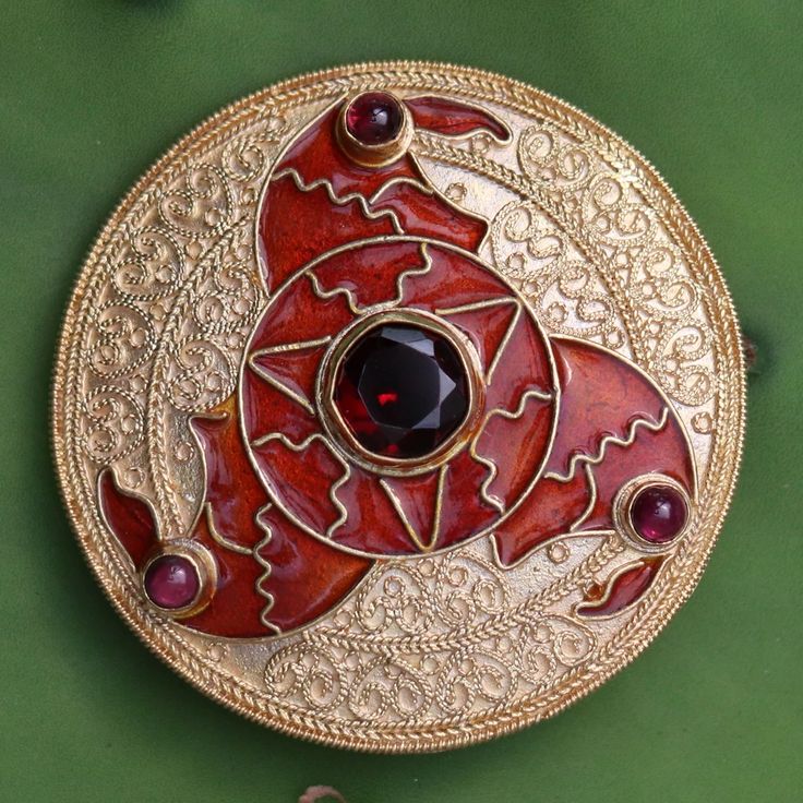 The famous 6th century Triskelion Brooch, as shown in Sutton Hoo collection in British Museum in London, is remarkably ,is reproduced in this vermeil pin, pendant and earrings. Crafted totally by hand as done in the ancient times. The Cloisonne motif is three whirling arms in the form of birds' heads. The eyes of the b Traditional Yellow Gold Collectible Brooch, Traditional Yellow Gold Pendant Brooches, Ornate Yellow Gold Brooch For Ceremonial Use, Ornate Yellow Gold Brooches For Ceremonial Use, Traditional Medallion Jewelry With Historical Design, Ornate Yellow Gold Brooches For Ceremonial Occasions, Ceremonial Medallion Jewelry With Historical Design, Traditional Jewelry With Historical Design For Collectors, Traditional Pendant Brooches For Formal Occasions