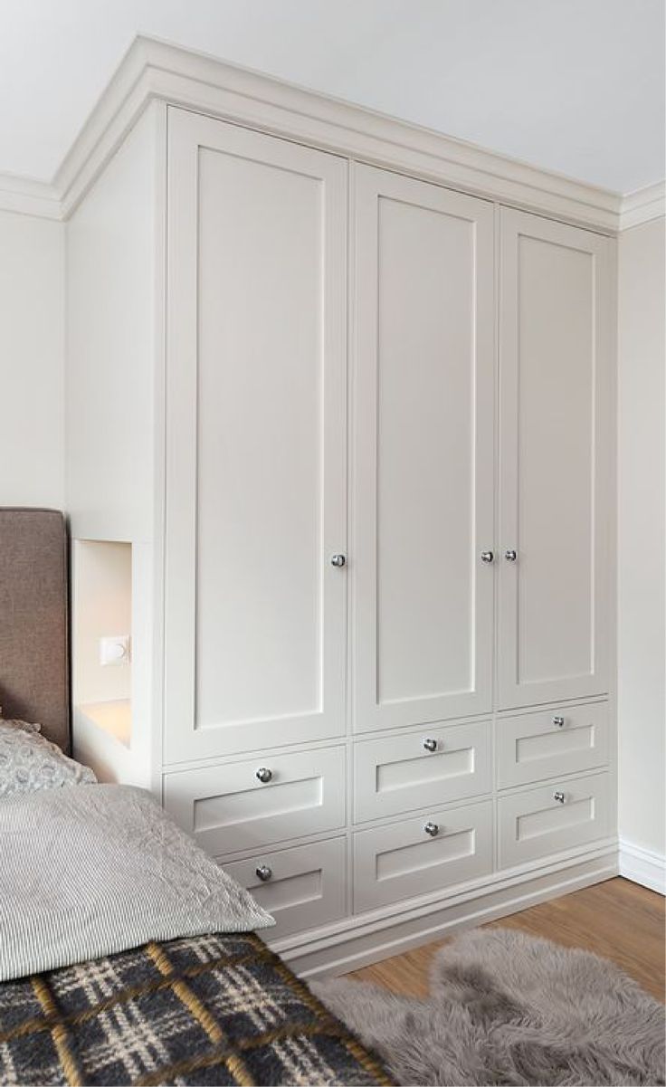 a bedroom with white closets and carpet on the floor