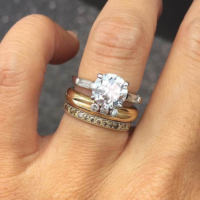 a woman's hand with two rings on it and a diamond ring in the middle