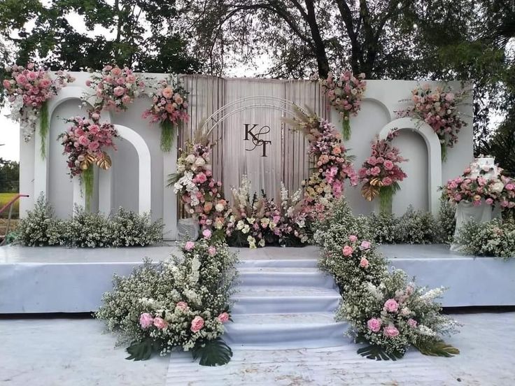 an outdoor ceremony setup with flowers and greenery