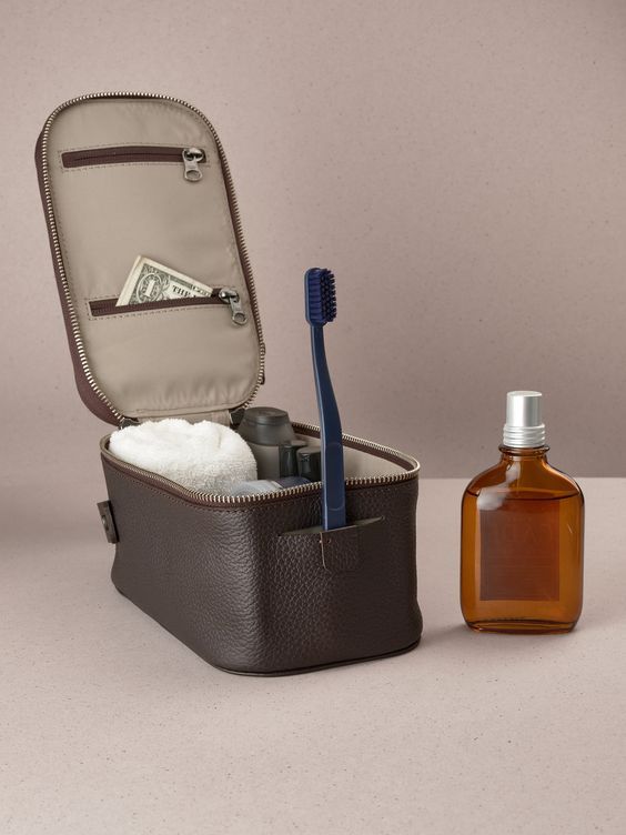 an open suitcase with toiletries in it next to a bottle of soap and a toothbrush