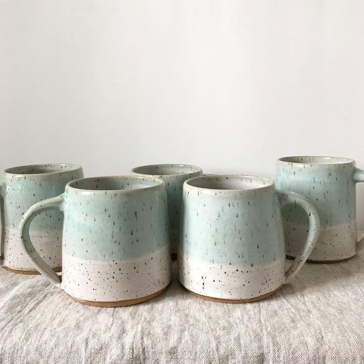 four coffee mugs sitting on top of a bed