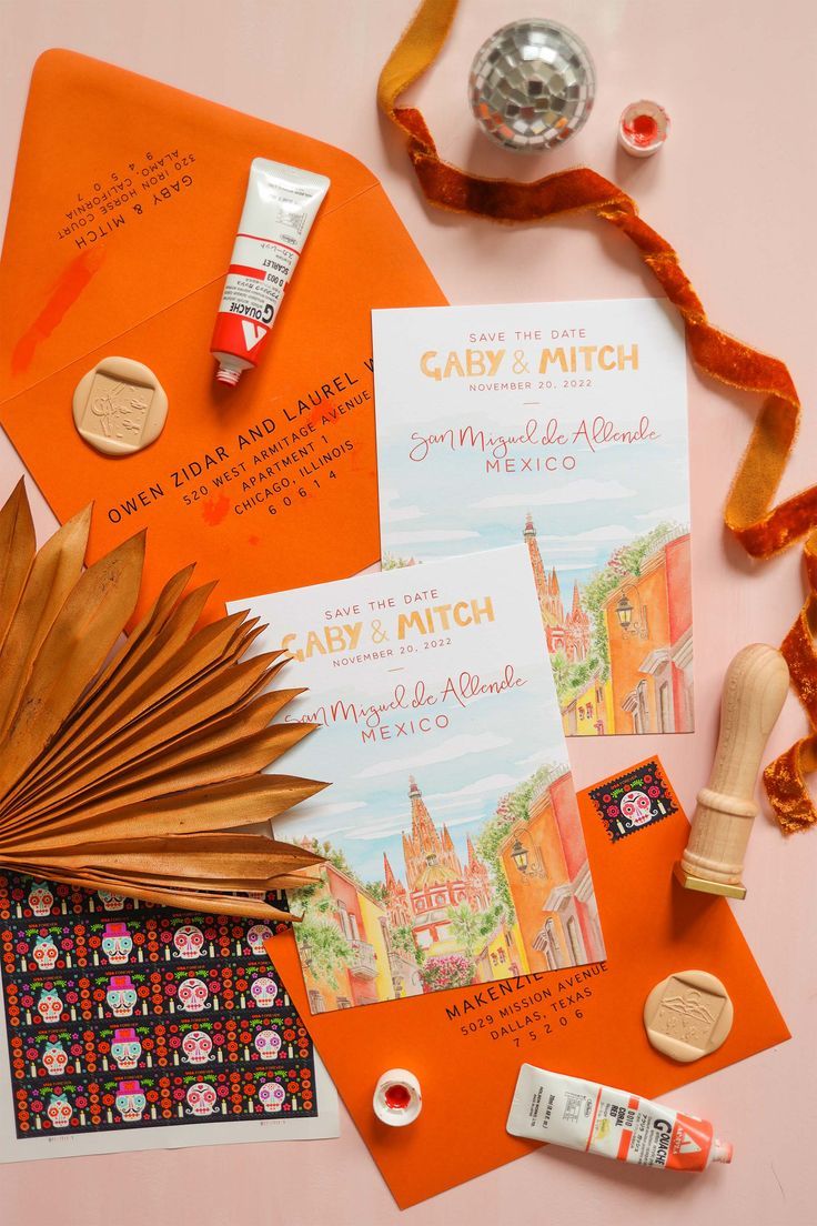 an assortment of crafting supplies including orange paper, scissors and other items on a table