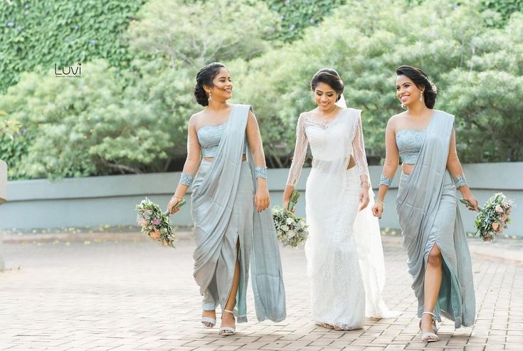 three bridesmaids are walking down the street together