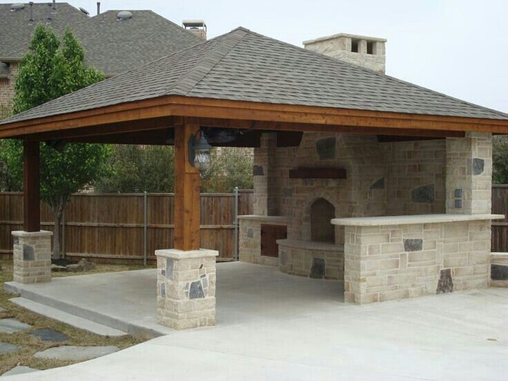 an outdoor bbq with stone walls and grilling area