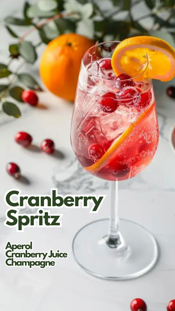 the cranberry spritz cocktail is garnished with an orange slice