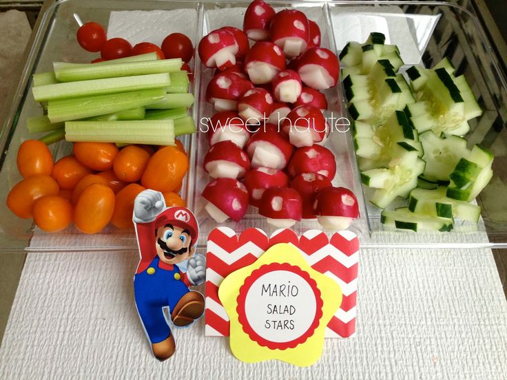 a plastic container filled with lots of veggies and other foods on top of a table