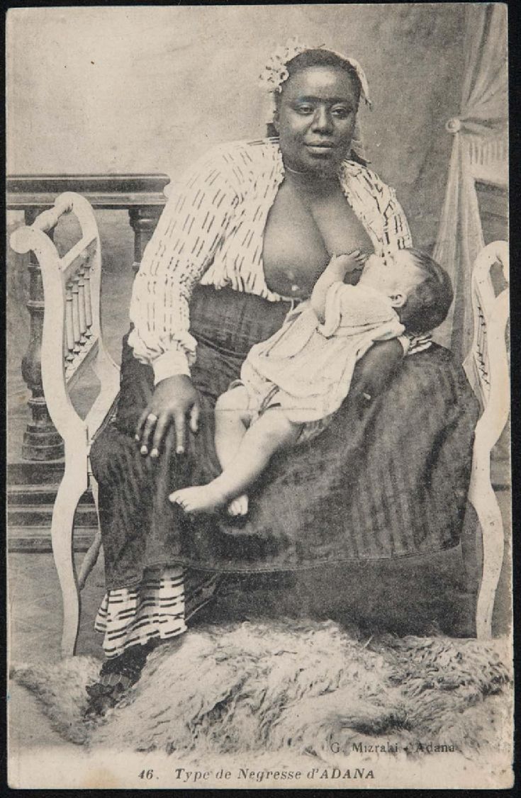 an old black and white photo of a woman holding a baby