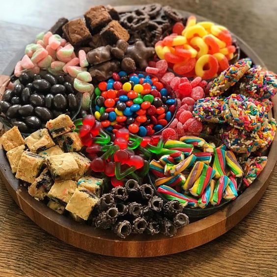 a wooden plate topped with lots of candy and candies