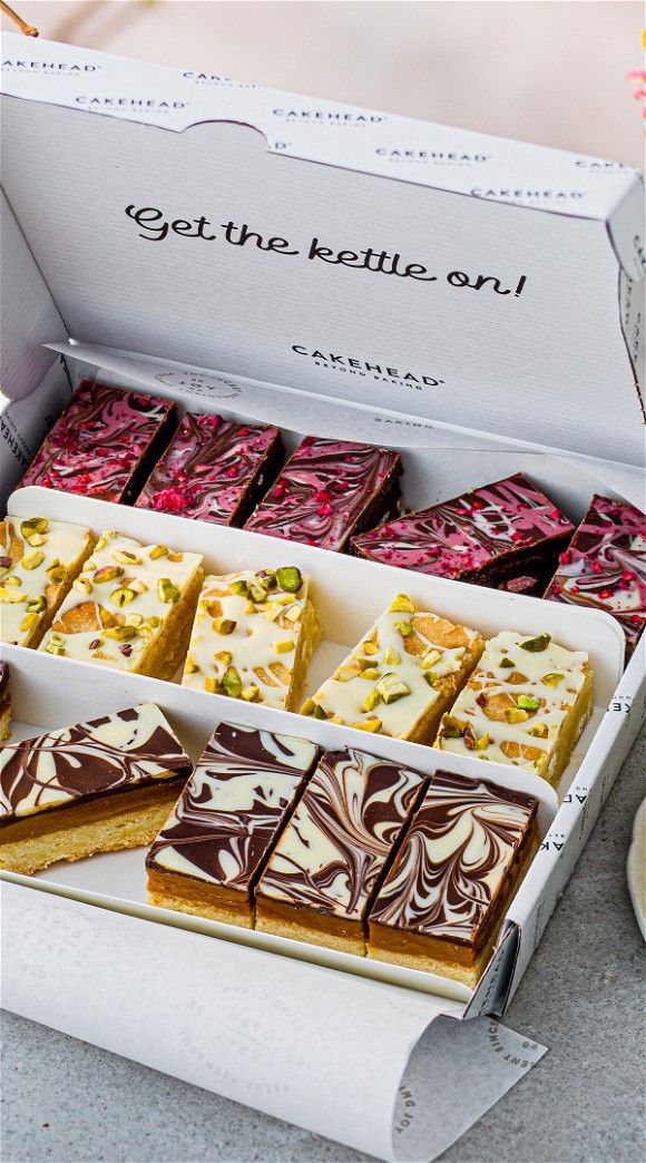 a box filled with lots of different types of desserts on top of a table