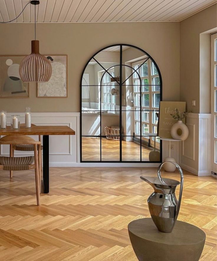 a living room filled with furniture and a large window next to a wooden floor covered in windows