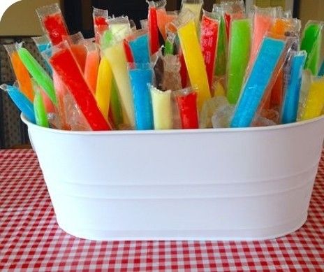 there are many different colored toothbrushes in the cup on the table with red and white checkered tablecloth