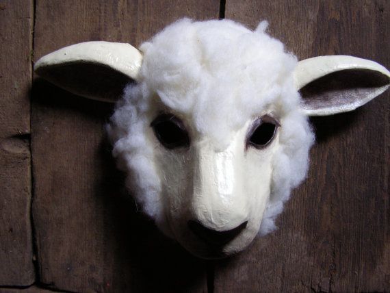 a white sheep head mounted on the side of a wooden wall