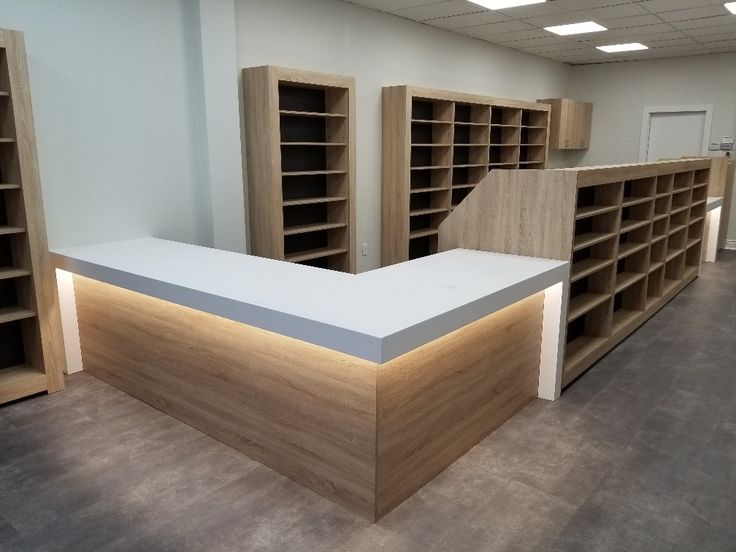 an empty room with wooden shelves and white counter top