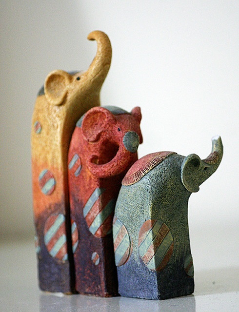 three small elephant figurines sitting next to each other