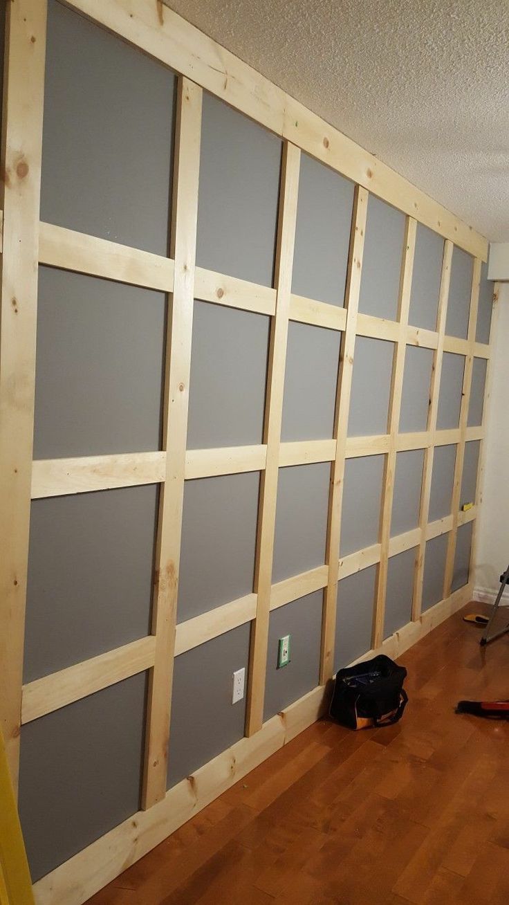 a room that is being remodeled with wood and gray walls, including the wall paneling