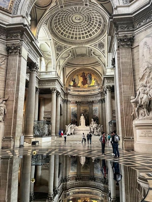 people are standing in the middle of a large room with marble walls and flooring