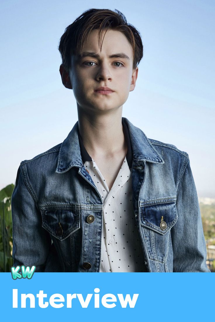 a young man in a denim jacket is looking at the camera