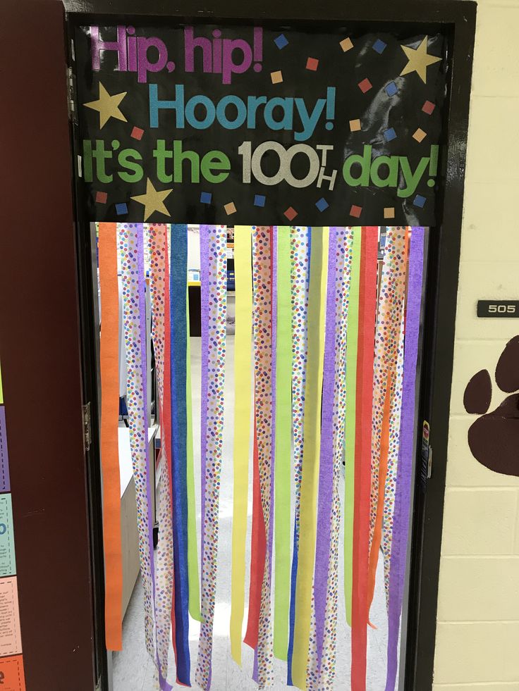 a door decorated with colorful streamers and dog's paw prints on the front