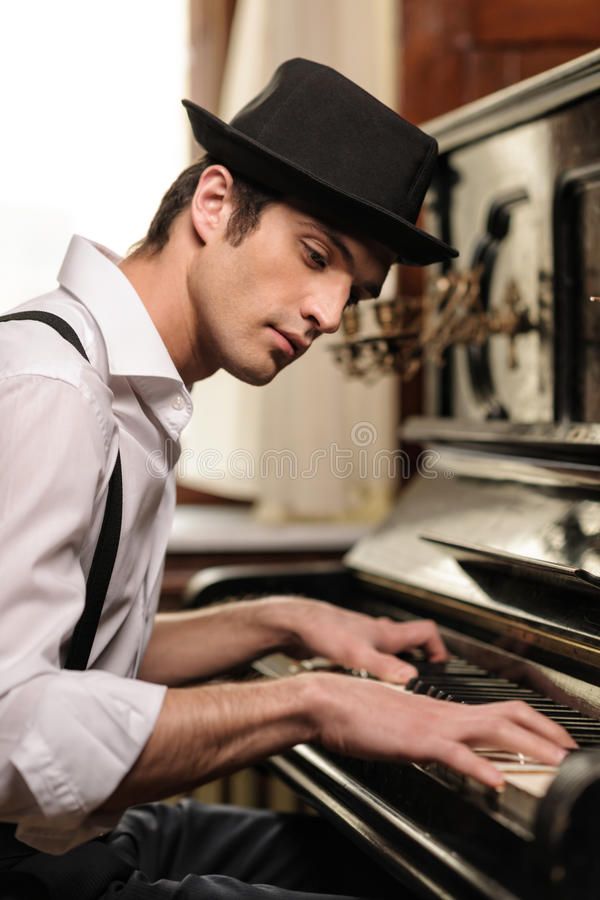 a man in a hat playing the piano