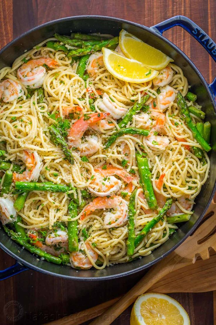 pasta with shrimp, asparagus and lemon in a skillet on a wooden table