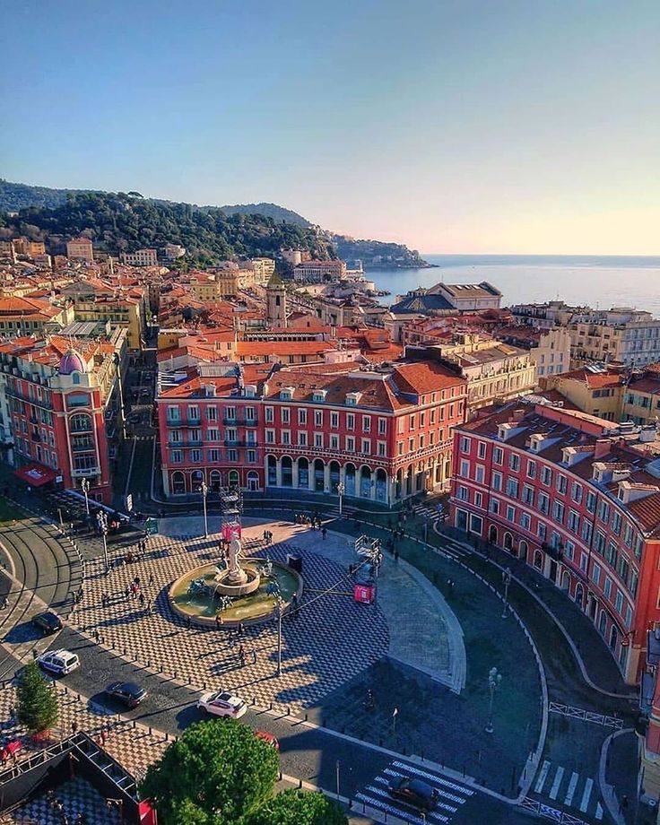 an aerial view of a city with lots of buildings and a fountain in the center