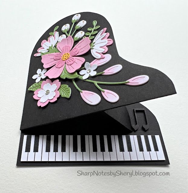 a close up of a piano with flowers on the top and bottom part of it