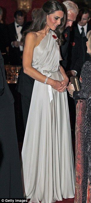 two women standing next to each other in front of an audience at a formal event