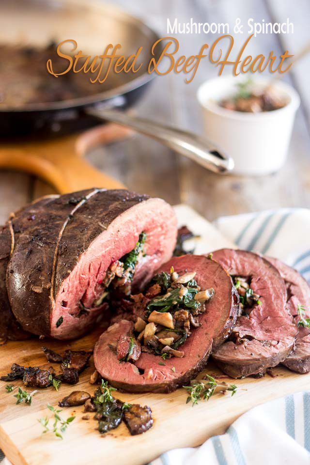 sliced beef on a cutting board with mushrooms and spinach