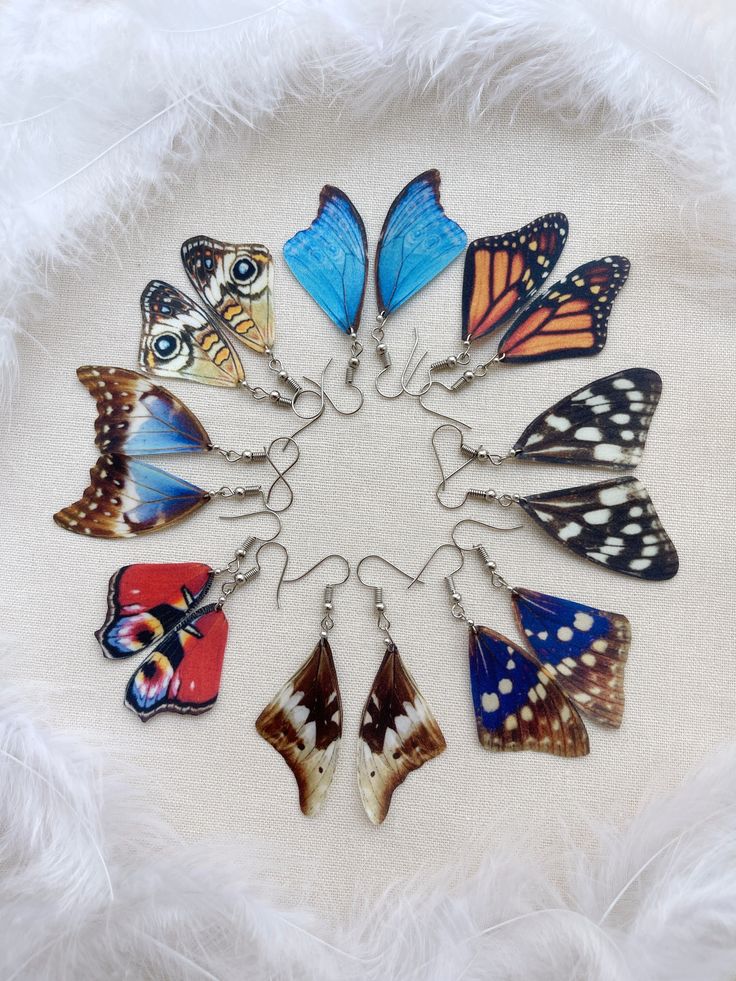 a bunch of butterflies that are on some kind of white furnishing with feathers around them