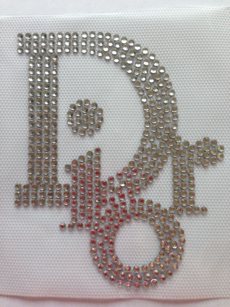 the letter b is made up of small silver and red beads on a white cloth