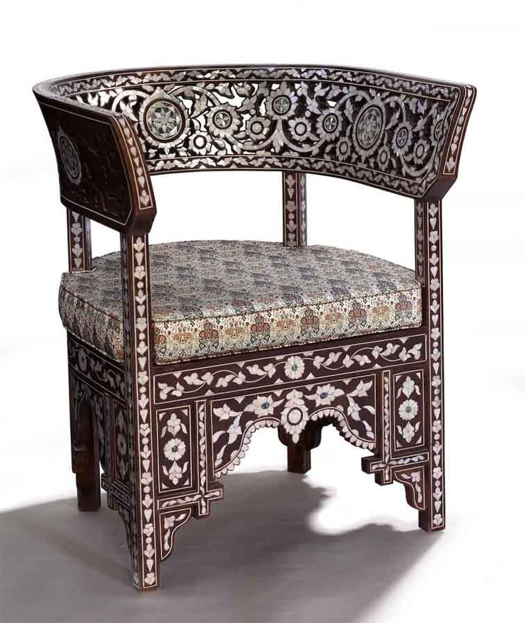 an ornate wooden chair with floral designs on the armrests and seat padding