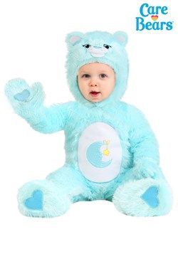 a baby in a blue teddy bear costume sitting on the ground with his hands up