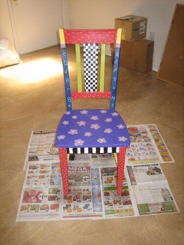 a colorful chair sitting on top of a newspaper